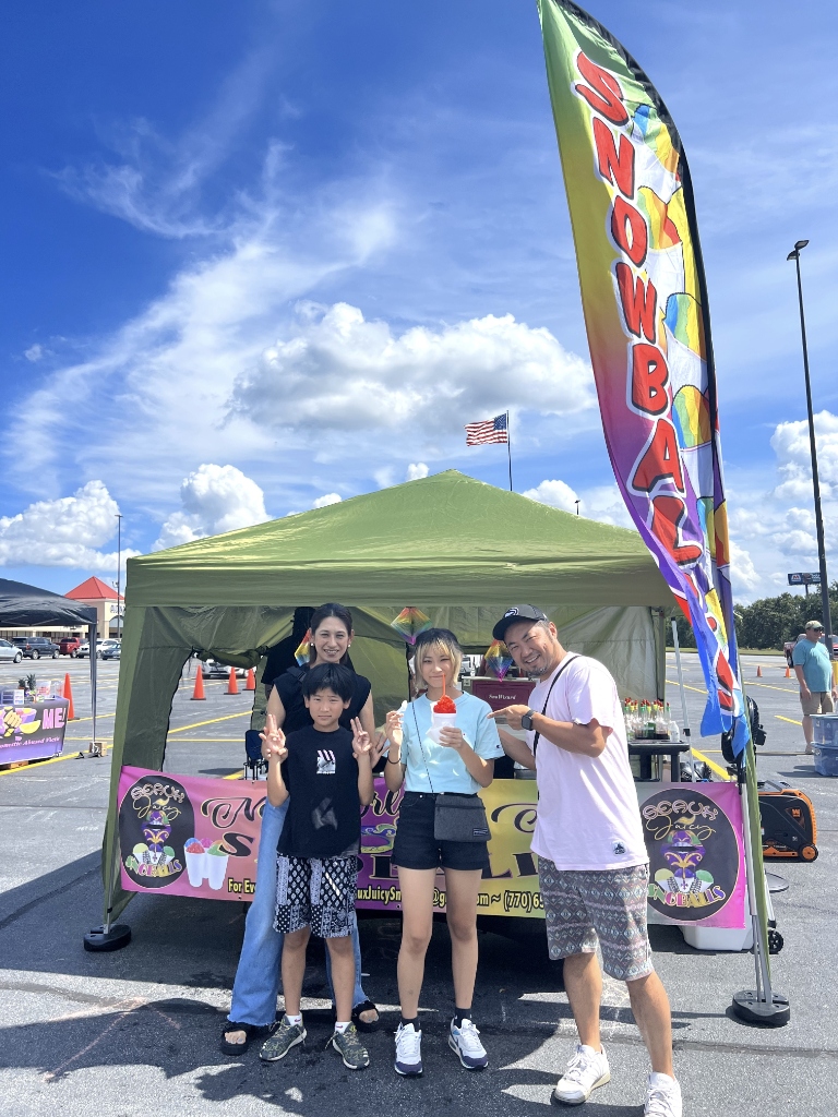 Family enjoying snoballs at Seaux Juicy stand outdoors