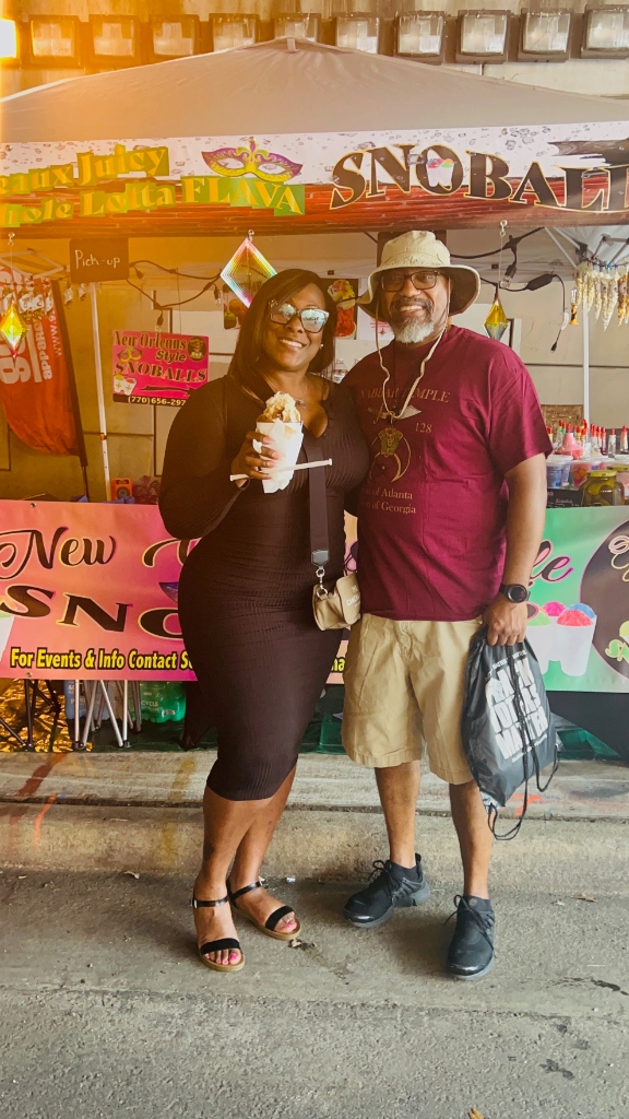 Couple posing with snoballs at Seaux Juicy event stand